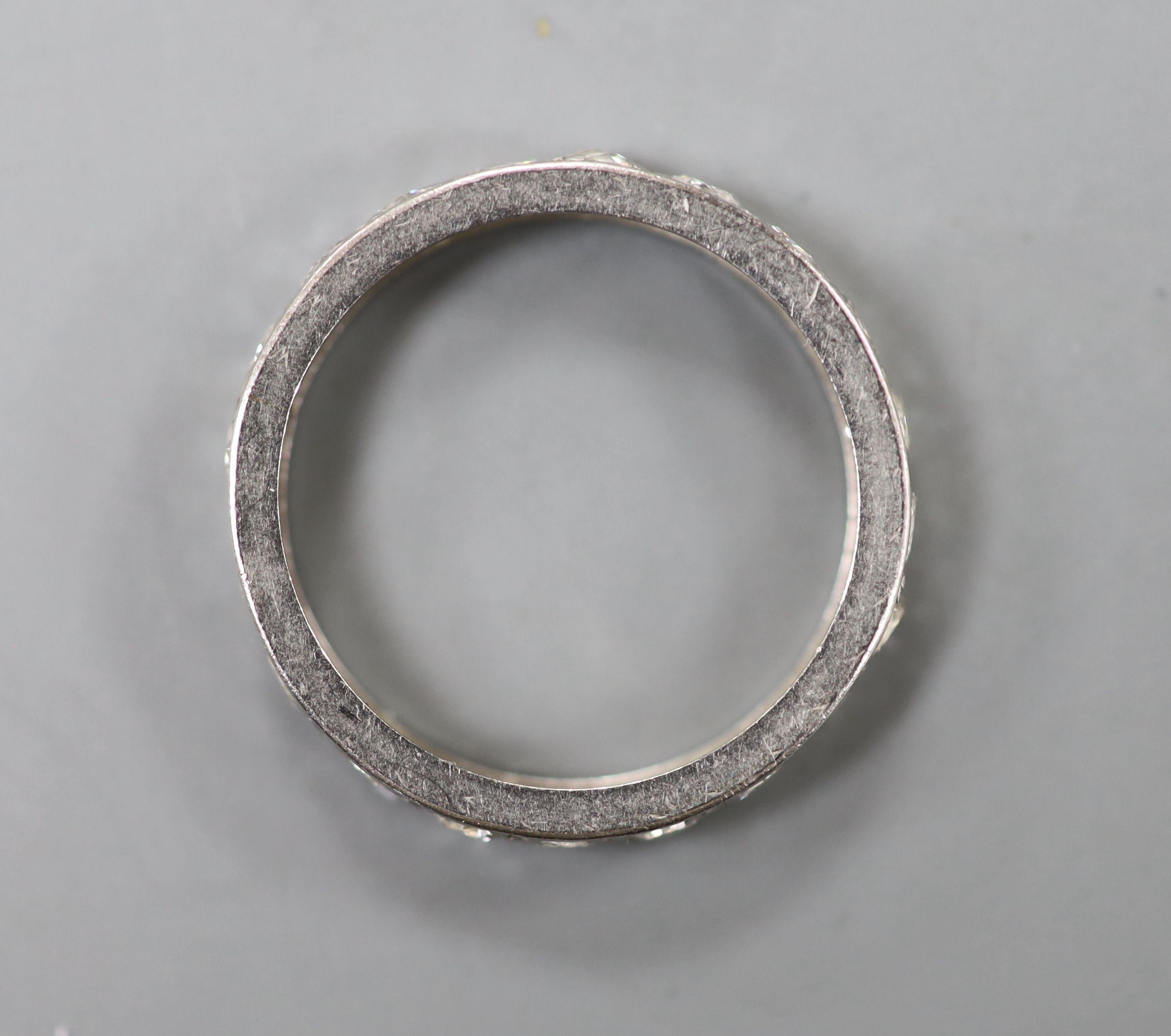 A white metal and diamond set full eternity ring, size K/L, gross 2.5 grams.